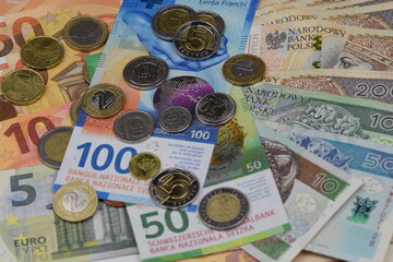 Swiss francs and Polish zlotys on euros banknotes background, credit in francs, frankowicze, kredyt...