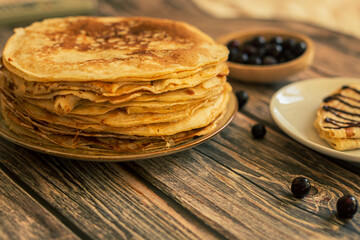 Delicious pancakes with chocolate sauce fresh blueberries on a rustic wooden table. Rustic brown table. 