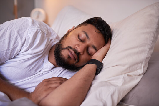 A Close Up Shot Of A Man Sleeping Peacefully In Bed On His Side