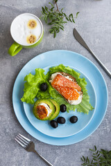 Healthy breakfast. Sandwich with smoked salmon, avocado cheese on lettuce salad leaves and coffee