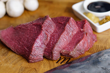 Raw ready for grill beef steaks near knife, mashrooms spices on cutting board. Healthy food concept