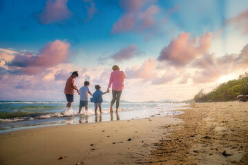 Asian family vacation holiday on the beach in the sunset