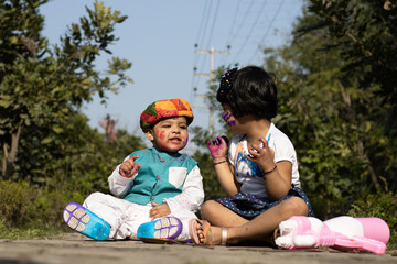 Happy Asian Indian Kids Boy And Girl Enjoying The Festival Of Colors With Holi Color Powder Called Gulal Or Rang
