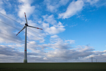 renewable energy, landscape with wind mill, Renewable energy, wind mill and high voltage cables at electricity pylons