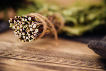 A dry birch broom lies on a wooden background. Accessories for baths and saunas.