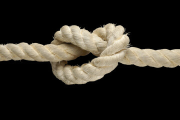 Thick white rope with a knot. Isolated on a black background.