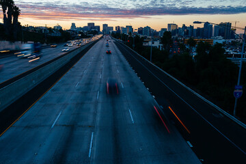 Cars speeding by on a freeway into the city skyline