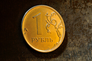 a Russian one ruble coin lies on a dark metal background. close-up