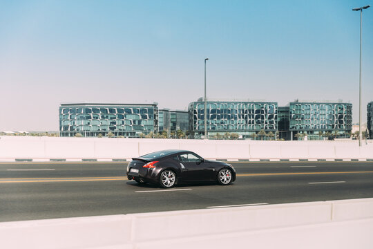 Dubai, UAE, United Arab Emirates - May 28, 2021: Black Nissan 350Z car fast mooving on street in Dubai. Nissan Fairlady Z Z33 sports car mooving on street in Dubai. Urban background.