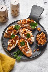 Chanterelle sandwiches with cheese. Open faced sandwich with creamy cheese, seasonings and pepper and fresh parsley on an old wooden background. Mock up. Top view.