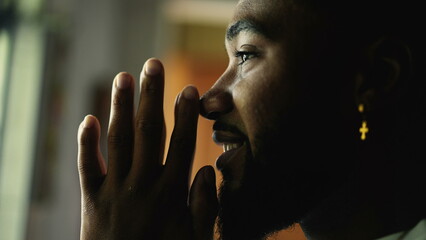 A spiritual black man praying with hands together