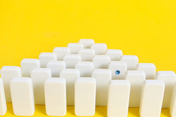 Rows white domino chips with one eye catching, concept is individual and not like everyone else.
