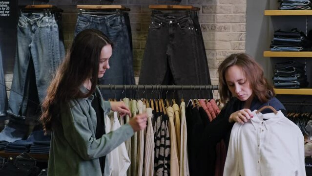 The stylist helps the girl to make a wardrobe