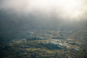 Fototapeta premium Delicate lights in the mist reveal the rocky landscape
