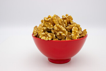 Peeled walnuts in red plate