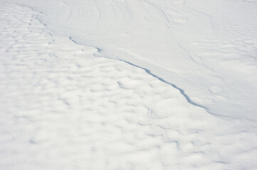Coarse texture of the snow, accented by a sliding sun light