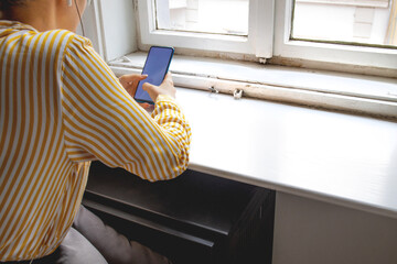 Hands of young woman typing on mobile phone