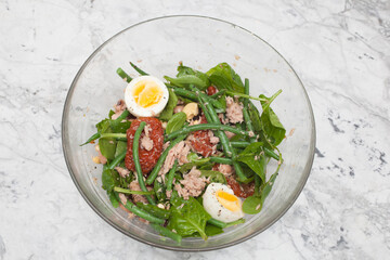 A nicoise salad, with tuna, boiled eggs and sundried tomatoes.