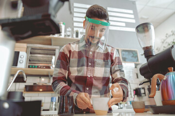 Portrait of smilling barista working at coffe shop during pandemic