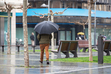 Man walks with umbrella in the city. Pamplona