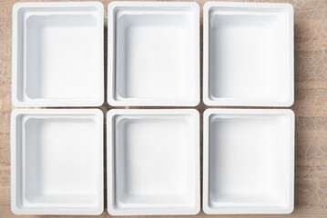 background of empty white plastic boxes for seedlings laid out on the table