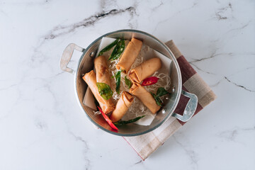 fried spring roll with salad and noodles in a dish isolated on mat top view on grey marble background