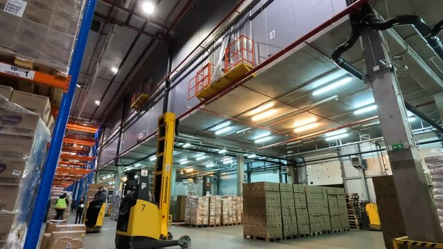 The work of modern equipment in the warehouse. Modern forklift in a warehouse with boxes