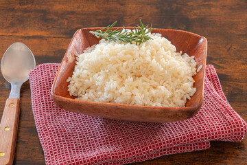 cooked rice in a bowl on a wooden background