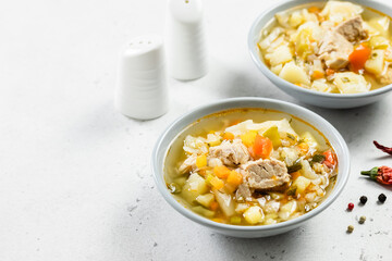 Homemade pork soup with vegetables in plates. Top view, copy space, flat lay.