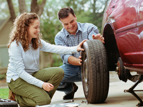Couple changing a car's tire together
