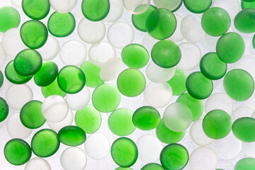 Green and white glass stones in a random pattern as an abstract background.