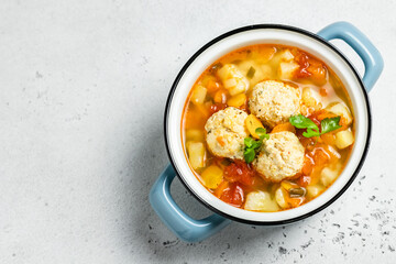 Homemade vegetable dietitioan meatball soup in pot. Top view, copy space.