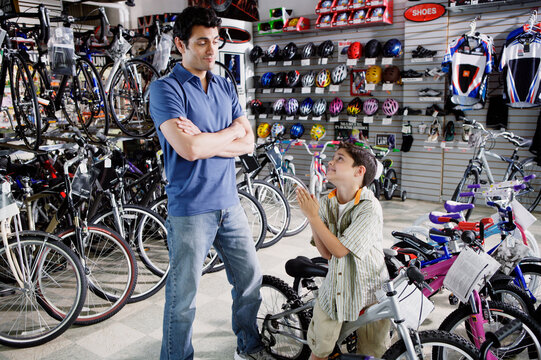 Son begging father for new bike in bike shop