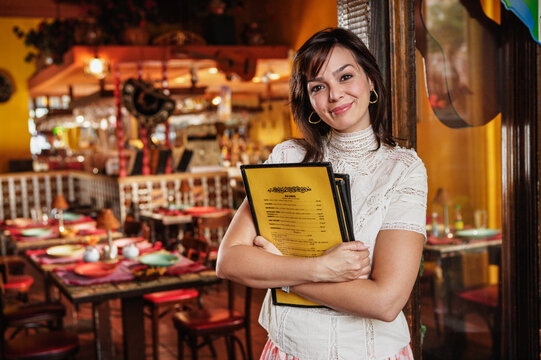 Portrait of hostess with menus in restaurant