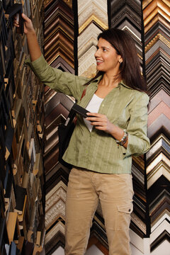 Young woman picking out picture frames