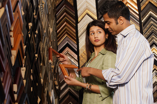 Young couple picking out picture frames