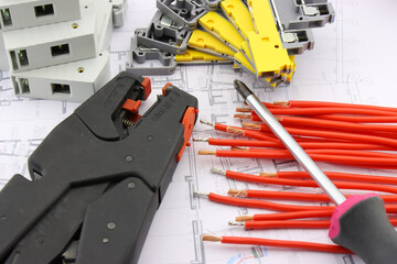 Tools for electrical installation on a close-up schematic diagram.