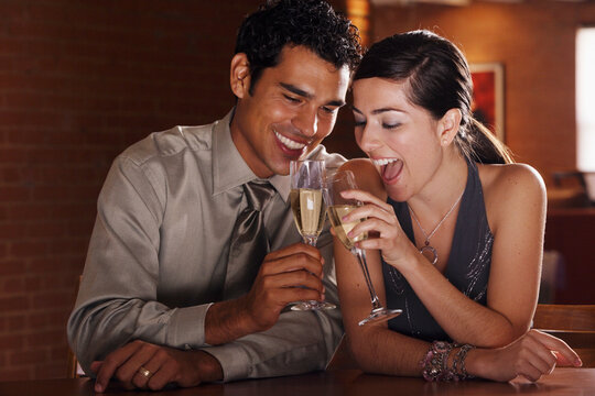 Hispanic couple toasting with champagne