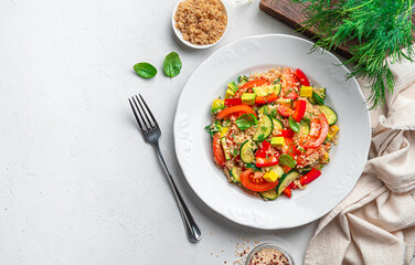 Vegetarian, healthy salad with quinoa, avocado, tomato, cucumber and sweet pepper on a gray background.