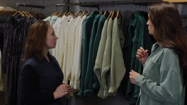 Sales assistant helping a woman to choose clothes