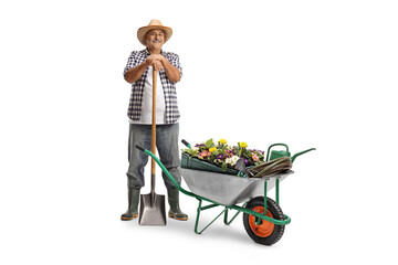 Full length portrait of a mature farmer with a shovel and a hand cart full of plants