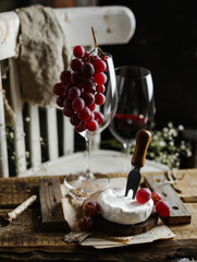 Wine camamber cheese with red grapes in the wine glass
