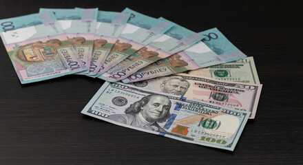 Hundred-ruble banknotes of the Republic of Belarus and US dollars. Close-up. The concept of the exchange of Belarusian rubles. Exchange rate. Belarusian monetary inflation.