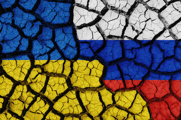 Flag of Ukraine and Russia on the texture of the cracked dry earth. The concept of conflict between...
