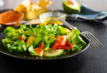 Fresh salad with avocado, cucumber, salmon. Dressing with honey, dijon mustard, olive oil and lemon juice