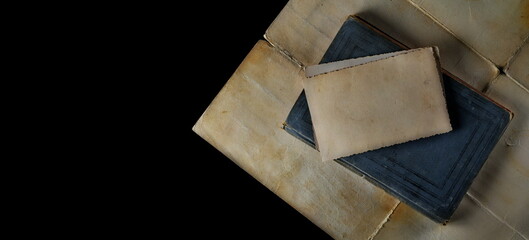 Blank old photo and old antique, ancient book isolated on black, top view