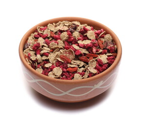 Mix integral wheat flakes with bran, linseed, grain pomegranate, dry cranberry, dried goji berry in bowl isolated on white
