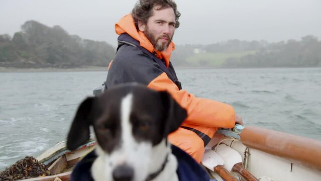 Fishing lifestyle, pull focus from fisherman to fisherman's dog