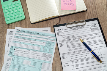 us tax form 1040 w4 w9 with pen on desk
