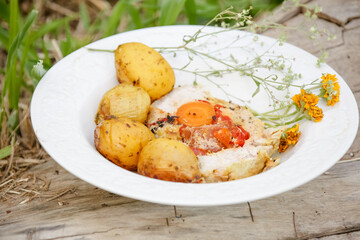 Loin in exotic dish with potato and onion herbs.
